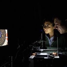 Wanyi Nie, associate professor of physics, and Dave Tsai, assistant professor of chemical and biological engineering, use a home-built optical microscope to probe the chiral properties of chiral perovskite crystals. 