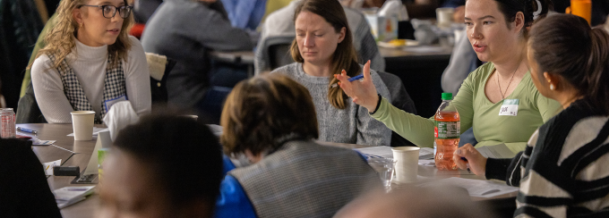 students discussing a topic together at a table. 