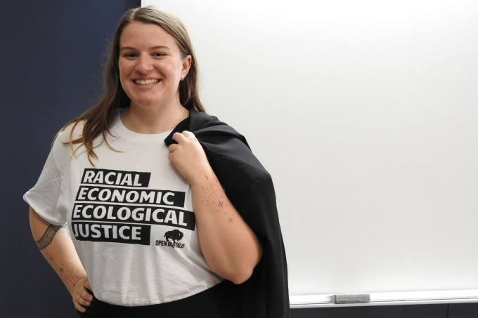 MSW student Kiara Owen with an Open Buffalo shirt that reads: "Racial Economic Ecological Justice.". 