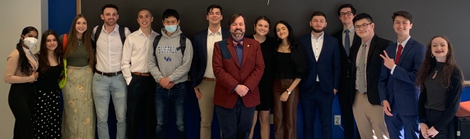The students from Integrating PPE (PHI 485), spring 2022, stand together in a classroom with their professor.