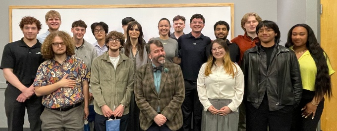 The students from Integrating PPE (PHI 485), spring 2026, stand together in a classroom with their professor.