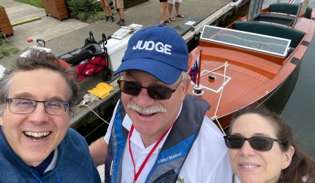 John Cerne, Tom Gruenauer and Andrea Markelz posing in front of a boat. 