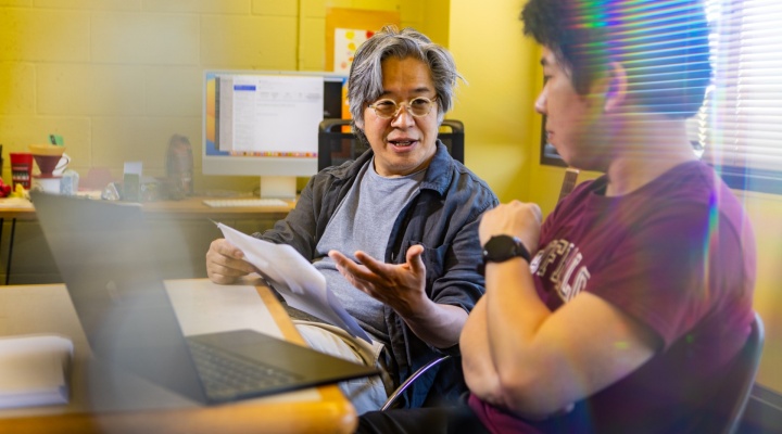 Professor Jong Han works with a student in Fronczak Hall. 