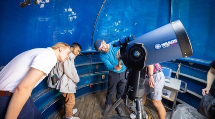 Students and Professor aligning a telescope.