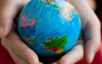 Hands holding a small globe. 