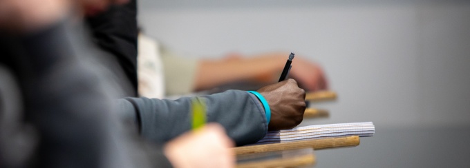 A close-up of a student's handwriting in a notebook during class. 