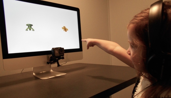 Toddler pointing at a computer screen doing activities. 