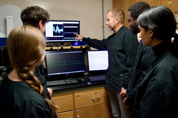 Dr. Paul Meyer and students in the lab looking at visualization of an action potential. 