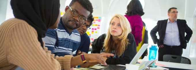students working at a table with post-it notes spread about. 