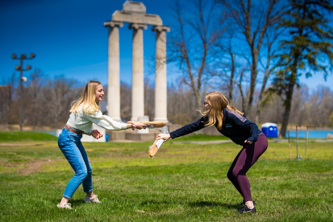 French Club members engage in bagette fencing on a sunny afternoon. 