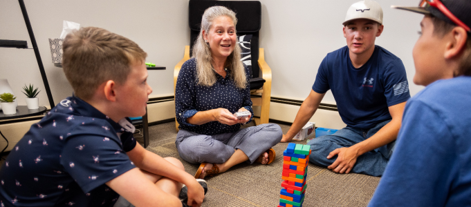 Rebecca Darszewski sitting with children around building blocks. 