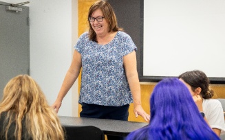 Tricia Lyman teaching in front of a classroom. 