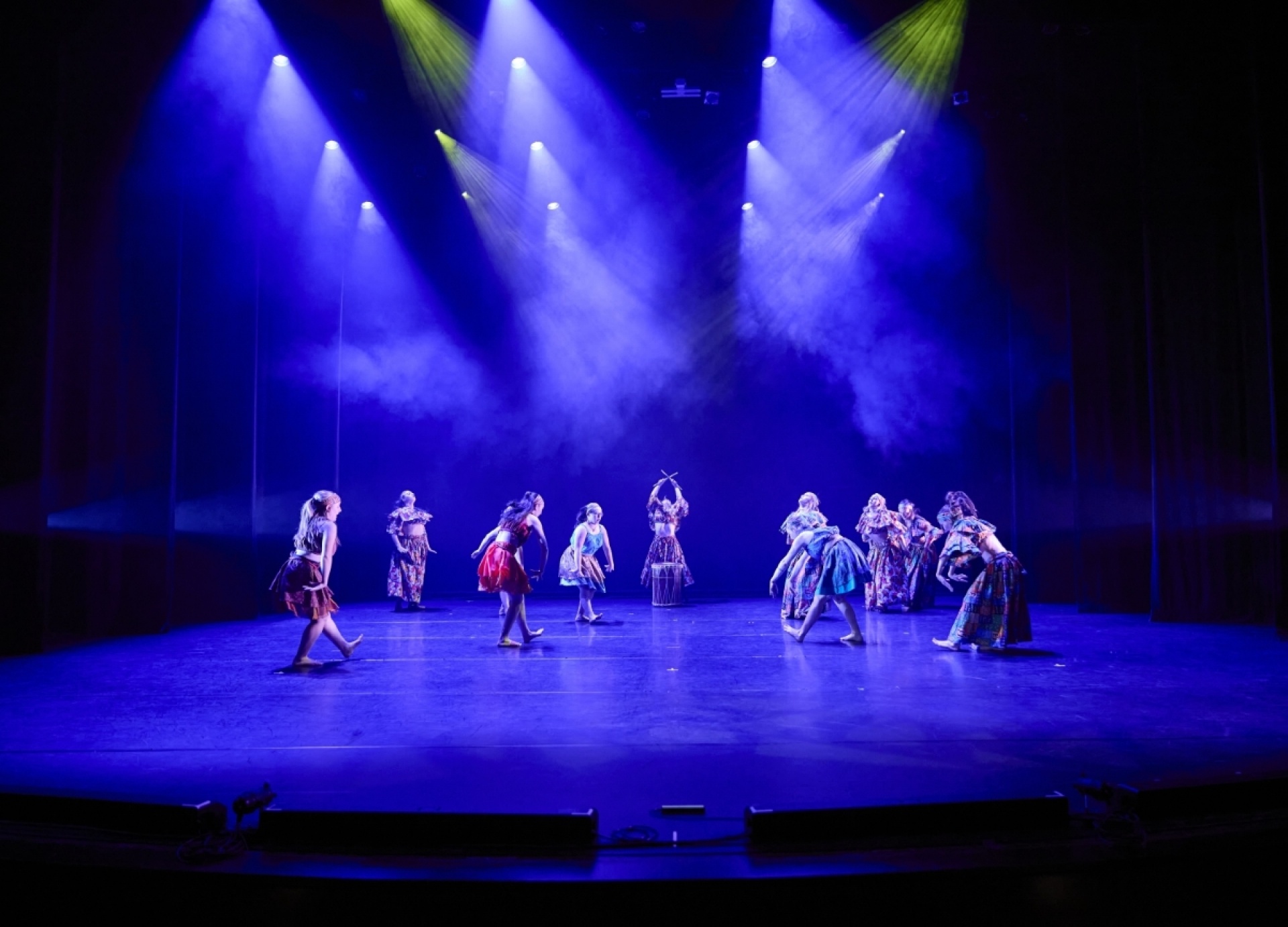 Many dancers onstage aglow. 