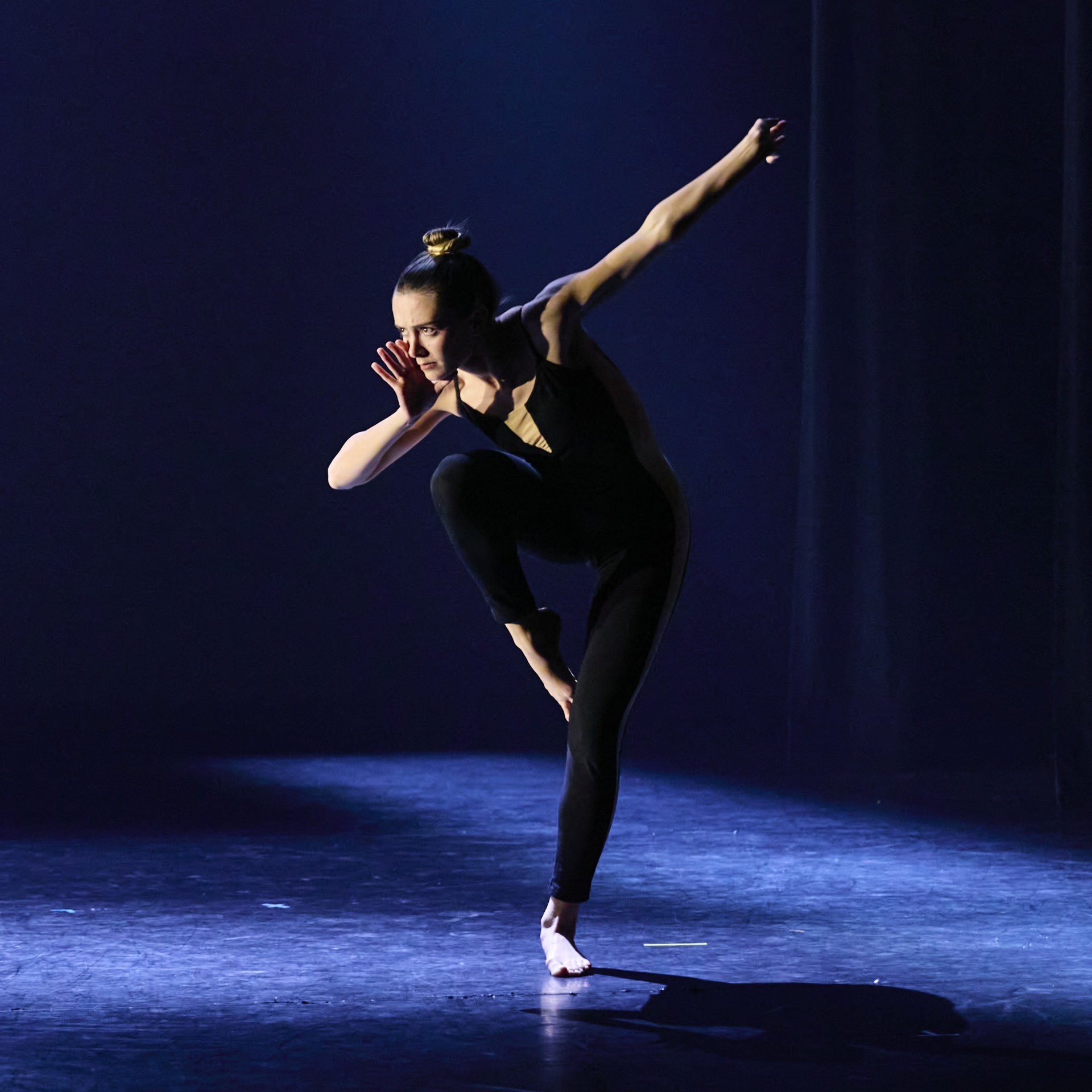 female dancer on stage with leg raised. 