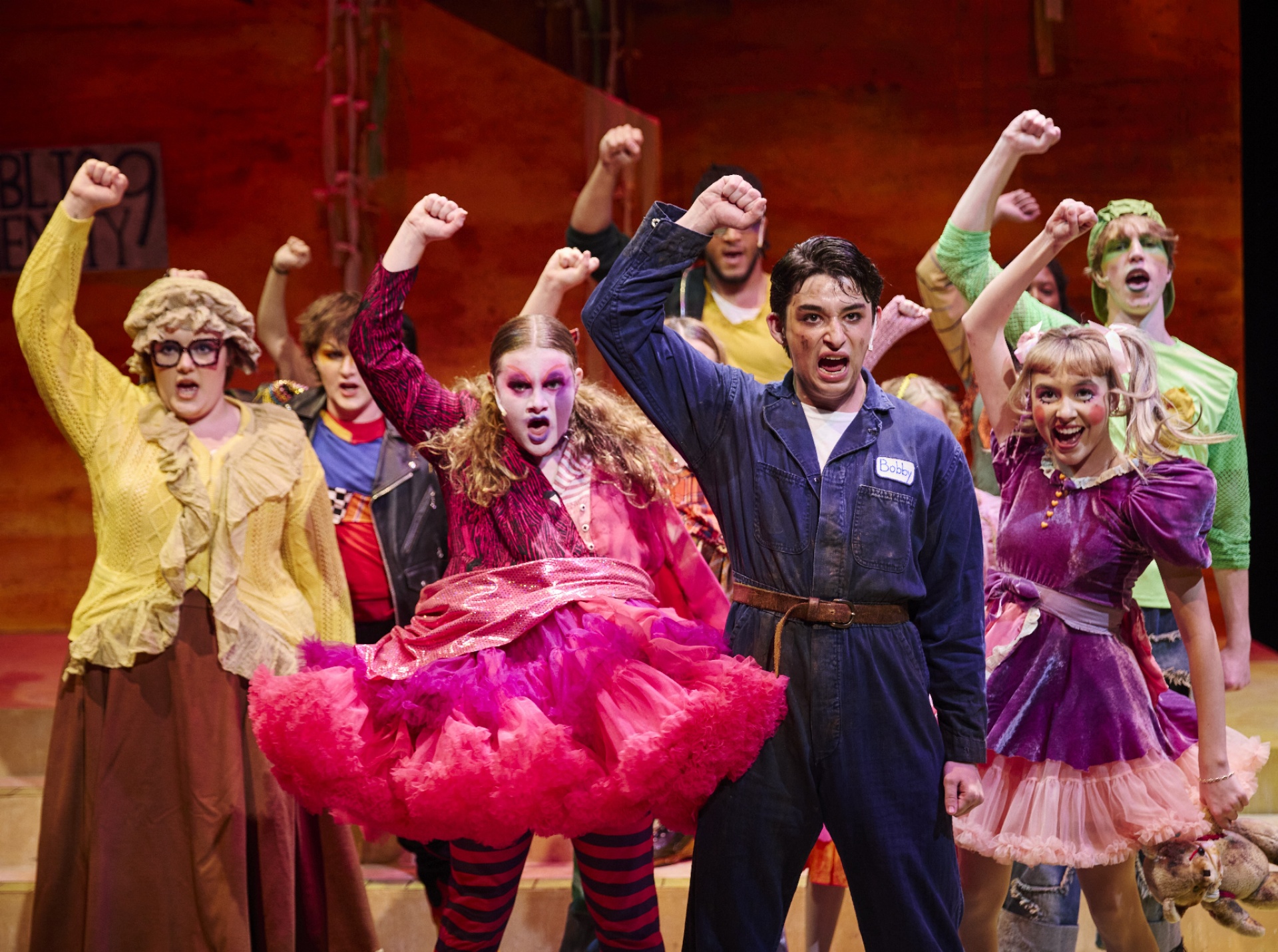 actors singing with firsts raised and clenched. 