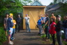 Peter Russell (center rear in blue cap) and Ed Steinfeld (to Russell's right) lead UB students on a tour of a Habitat for Humanity house designed by UB architecture and planning students. Photo: Douglas Levere