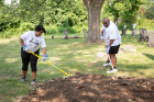 Isabel Ortiz, who retired from the former Sudent Response Center, and Fred Brown, a student in the Student Affairs concentration of the Higher Education Administration EdM program, do some raking at Concordia Cemetery.