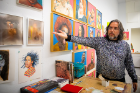Cristiano Pereira shows his artwork to visitors.