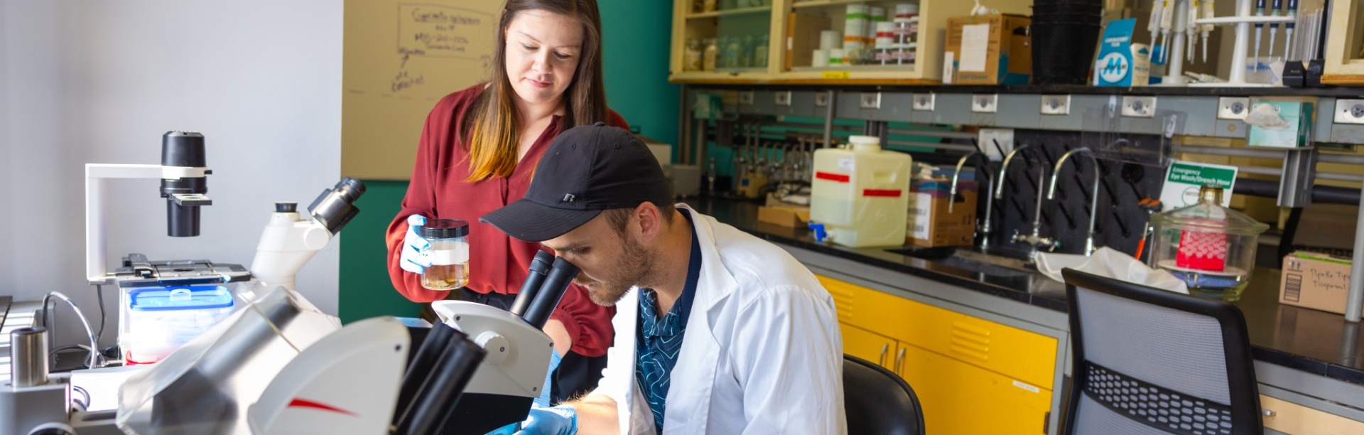 Corey Krabbenhoft, with the department of Biological Sciences, works in a research lab with a student.